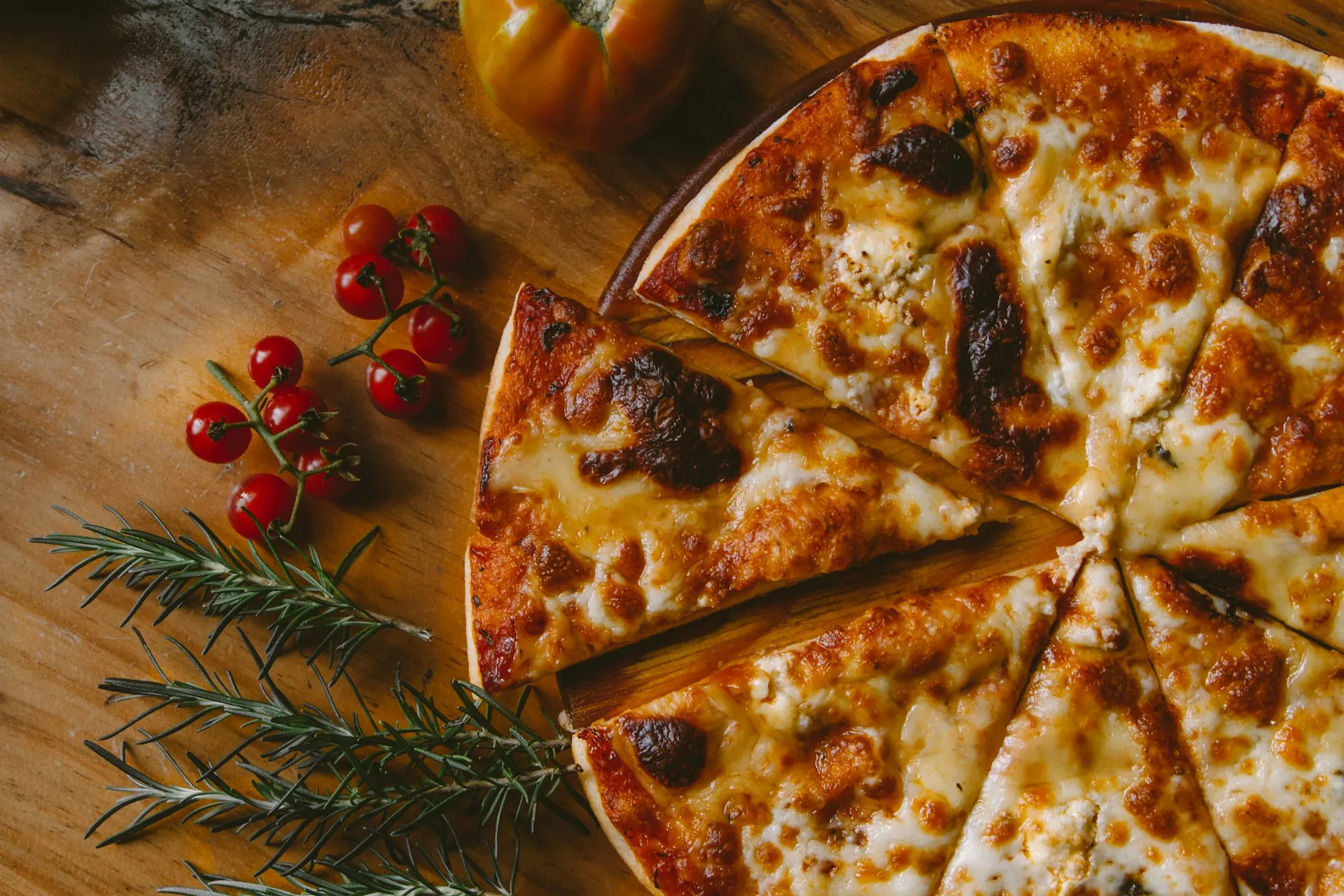 Skivad ostpizza på träbricka